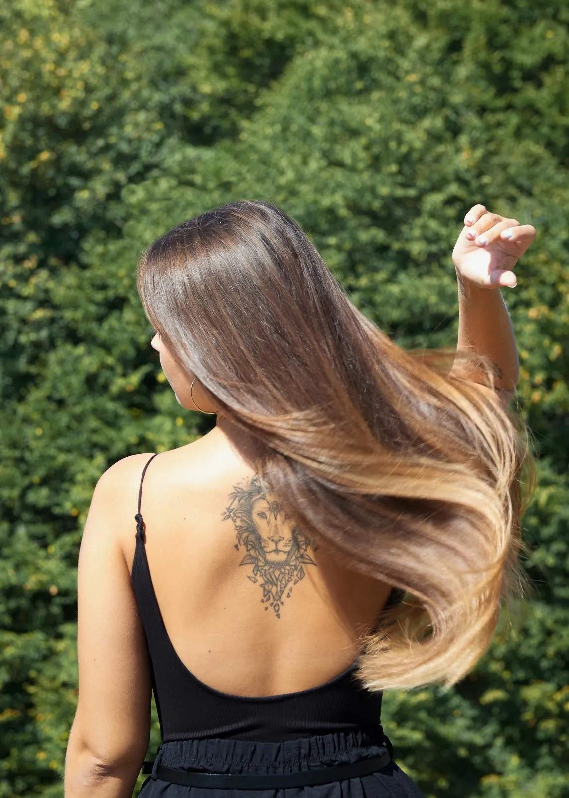 Balayage-Ergebnis — langes Haar mit weichen blonden Strähnchen, Rückansicht im Garten