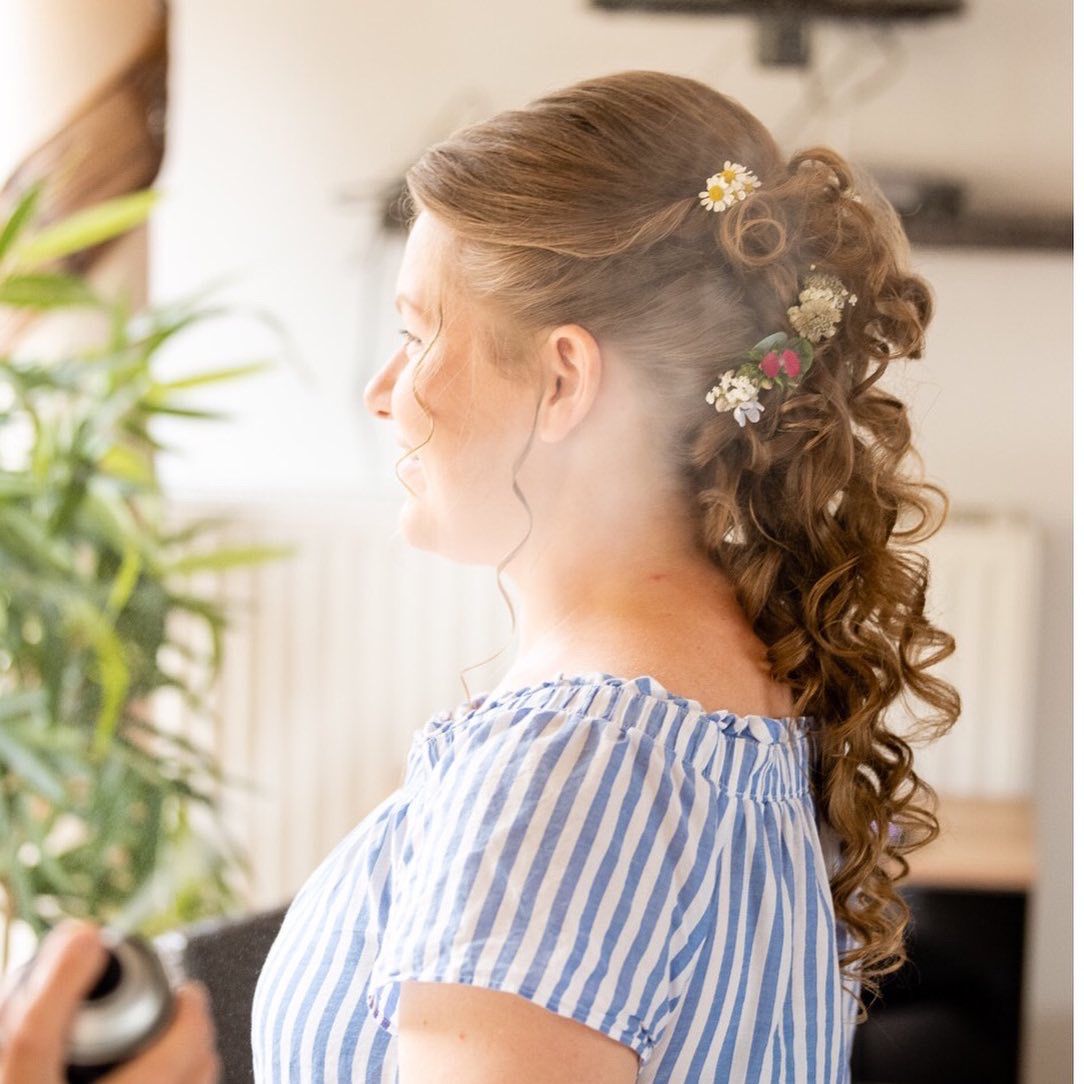 Halb-offene Brautfrisur mit voluminösen Locken und Wiesenblumen-Haarschmuck