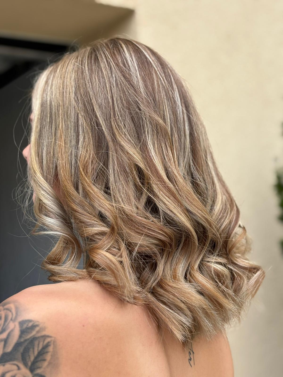 Blonde Wellen mit hellen Highlights und weichen Locken am Schnittansatz